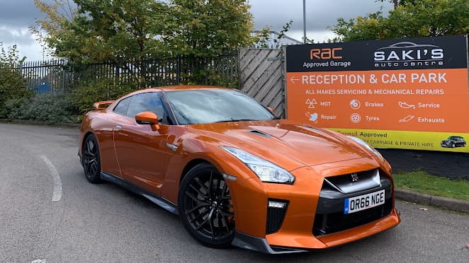 Saki's Auto Centre reception and car park sign showing RAC approval and service list